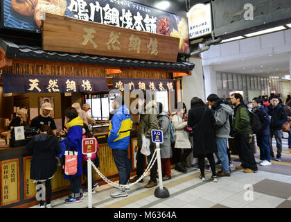 Kunden stehen in der Linie in einem berühmten traditionellen Japanischen cookie Shop in den belebten Handelszentrum in Tenjin, Fukuoka, Japan. Stockfoto