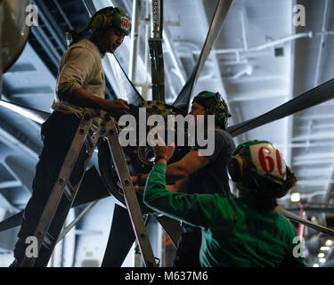 ARABIAN GULF (Feb. 11, 2018) Aviation Maintenance Administrationman 1. Klasse Michelle Reese, rechts, Pässe Lappen zu Mate 2 Aviation machinist Klasse Bhakta Siwa, Links, und Aviation Machinist Mate 2. Klasse Christopher Lee als Sie sauber ein Propeller im Hangar Bucht der Flugzeugträger USS Theodore Roosevelt (CVN 71). Theodore Roosevelt und ihre Carrier strike Group werden in den USA 5 Flotte Bereich für Maßnahmen zur Erhöhung der Sicherheit im Seeverkehr im Einsatz Verbündeten und Partnern zu beruhigen und der Freiheit der Schiffahrt und des freien Handels in der Region erhalten. (U.S. Marine Stockfoto