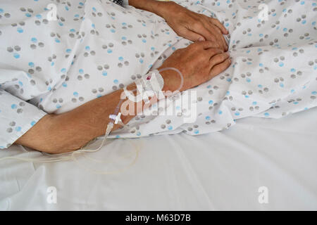 Soft Focus intravenöse Leitung in der Hand eines Patienten - Soft Focus Hand des alten Mannes mit IV-Linie auf dem Bett im Krankenhaus verschwommenen Hintergrund. Stockfoto