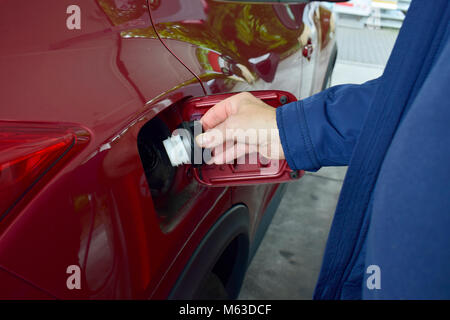 Ein Mann schließen ein Benzin tank in seinem Auto. Vergessen Sie nicht für Ihre Benzintank in Ihrem Auto in der Nähe vor der Fahrt. Sicherheit fahren. Stockfoto