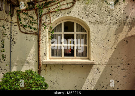 Gewölbte Fenster eines, aus Stein gebauten Ferienhaus zu Hause. Traditionelle Ferienhaus außen Stockfoto