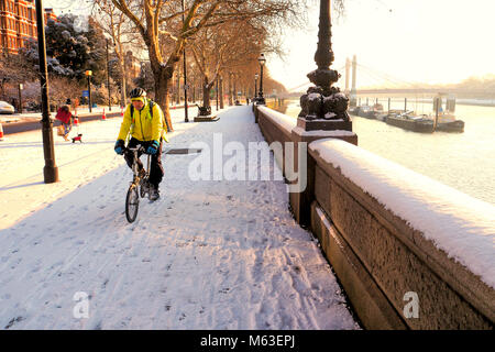 London, Großbritannien. 28 Feb, 2018. UK Wetter: Central London bedeckt war im Schnee als das kalte Wetter vor in South East England gefegt. Ein Mann Zyklen auf dem Fußweg entlang der Themse © Brian Minkoff/Alamy leben Nachrichten Stockfoto