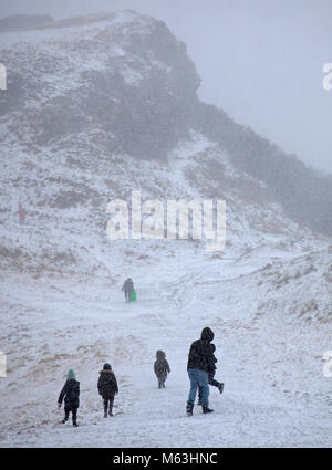 Edinburgh, Schottland, Großbritannien. 28. Februar, 2018. Was zunächst als eine spannende Familie Winter Urlaub in Holyrood Park Spaß Schlittenfahren zu haben in einen Alptraum mit kleinen Kindern zu heulen, wie sie in einem Blizzard Schnee gefangen wurden. Das Radio hatte gerade bekannt gegeben, dass die amber Alert für schwere Wetter nur eine rote Warnmeldung geworden war. Stockfoto