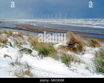 Marske am Meer North Yorkshire UK vom 28. Februar 2018 UK Wetter. Weiterhin Schnee mit einem starken Ostwind sorgen für kalte Bedingungen an einem einsamen Strand mit schneebedeckten Klippen und ein Blick in Richtung Redcar Offshore-windfarm, schwarze Wolken am Horizont weitere Schnee tragen fällt noch kommen. Credit: Peter Jordan NE/Alamy leben Nachrichten Stockfoto