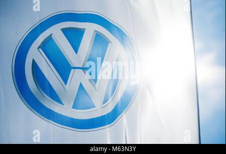 23. Februar 2018, Deutschland, Hannover: Helles Sonnenlicht strahlt durch das Logo der Autobauer Volkswagen (VW) auf eine Flagge ausserhalb ein VW-Autohaus. Im Jahr 2017 hat VW mehr Autos als je zuvor ausgeliefert werden. 10, 74 Millionen Autos an die Kunden weltweit verkauft und rechnet das Unternehmen mit einem positiven Ergebnis für das Geschäftsjahr 2017. Foto: Julian Stratenschulte/dpa Stockfoto