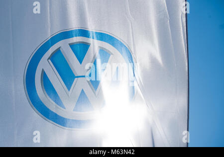 23. Februar 2018, Deutschland, Hannover: Helles Sonnenlicht strahlt durch das Logo der Autobauer Volkswagen (VW) auf eine Flagge ausserhalb ein VW-Autohaus. Im Jahr 2017 hat VW mehr Autos als je zuvor ausgeliefert werden. 10, 74 Millionen Autos an die Kunden weltweit verkauft und rechnet das Unternehmen mit einem positiven Ergebnis für das Geschäftsjahr 2017. Foto: Julian Stratenschulte/dpa Stockfoto