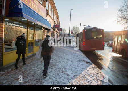 Merton, London, UK. 28. Februar 2018. UK Wetter. Die Pendler zu Blue Sky, Frost und Schnee über Nacht in South West London, mit mehr zu kommen. Die wichtigsten Straßen durch modernes Stadtzentrum bleiben frei von ständigen Schnee. Credit: Malcolm Park/Alamy Leben Nachrichten. Stockfoto