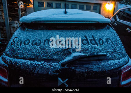 Das Tier aus dem Osten und Sturm Emma verlassen ein Abstauben des Schnees auf der Heckscheibe eines Autos, bevor der Schnee kommt mit den Worten Snowmageddon in den Schnee, Wales, Großbritannien Stockfoto