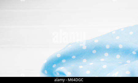 Hellblau Polka Dots gefalteten Tischdecke über gebleicht Holztisch. Top Bild anzeigen. Copyspace für Ihren Text Stockfoto