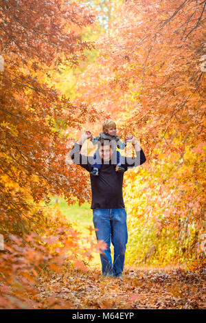 Vater Sohn piggyback Ride im Herbst Park Stockfoto