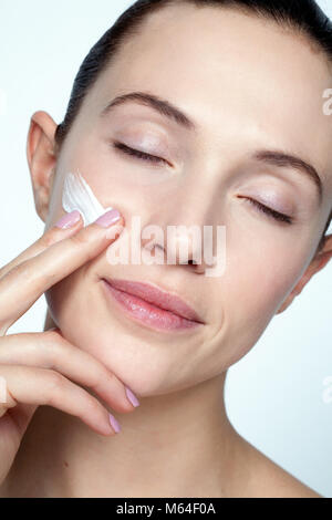 Frau Anwendung Gesichtscreme Stockfoto