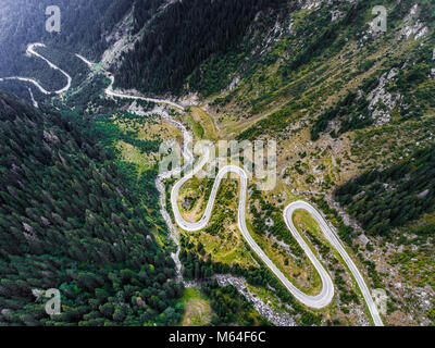 Kurvenreiche Straße in den Bergen. Wald und Fluss sichtbar, vorbeifahrende Autos. Transfagarasan Straße in Trasnylvania, Rumänien, Europa. Stockfoto