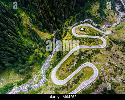 Kurvenreiche Straße in den Bergen. Wald und Fluss sichtbar, vorbeifahrende Autos. Transfagarasan Straße in Trasnylvania, Rumänien, Europa. Stockfoto