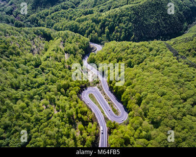 Kurvenreiche Straße in den Wald. Siebenbürgen, Rumänien, Europa. Lkw auf der Straße. Stockfoto