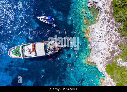 Menschen Schwimmen im klaren blauen Wasser der Antipaxos Insel, in der Nähe von Korfu - Korfu, Griechenland. Tägliche Ausflüge zu der kleinen Insel von Gaios Stadt, Paxo Stockfoto