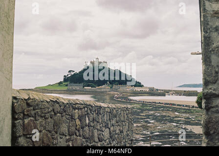 St. Michael's Mount, Cornwall, Großbritannien. Blick auf die Gezeiten Insel vom Ufer bei Ebbe. Bewölkt bewölkten Himmel, weiches Licht auf der Insel Stockfoto