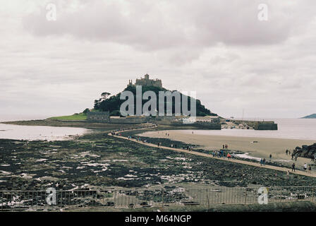 St. Michael's Mount, Cornwall, Großbritannien. Blick auf die Gezeiten Insel vom Ufer bei Ebbe. Bewölkt bewölkten Himmel, weiches Licht auf der Insel Stockfoto