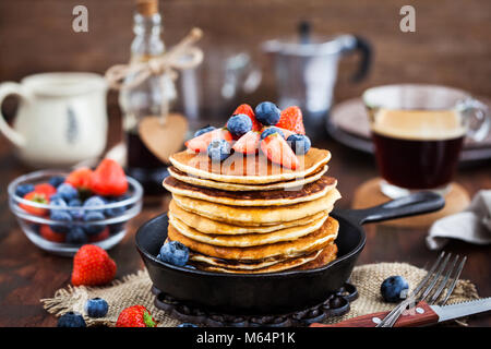 Stapel von frisch zubereiteten Banana Pancakes mit frischen Beeren und Ahornsirup zum Frühstück Stockfoto