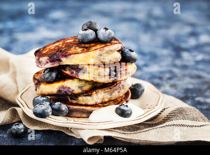 Stapel von frisch zubereiteten Blueberry ricotta Pfannkuchen mit frischen Beeren, Joghurt und Honig zum Frühstück Stockfoto