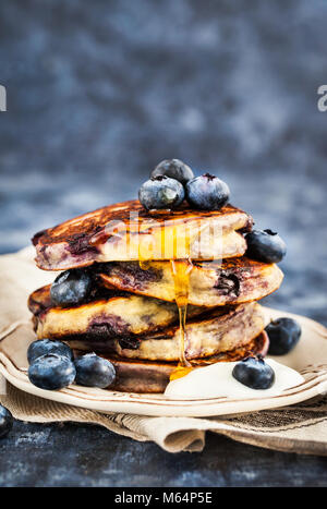 Stapel von frisch zubereiteten Blueberry ricotta Pfannkuchen mit frischen Beeren, Joghurt und Honig zum Frühstück Stockfoto