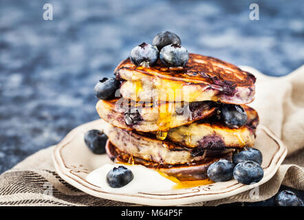 Stapel von frisch zubereiteten Blueberry ricotta Pfannkuchen mit frischen Beeren, Joghurt und Honig zum Frühstück Stockfoto