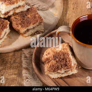 Zimtstange swirl Krümel Kuchen und Kaffee auf einer Holzplatte Stockfoto