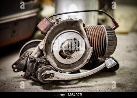 Sehr dreckig und öliger Motor aus alten italienischen Roller auf dem Boden der Garage Stockfoto