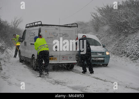 Die Menschen drücken Sie einen Van, der auf einem Hügel auf der A 30 in der Nähe von Land's End in Cornwall gestrandet nach schweren Schnee, die Fahrbedingungen erschwert. Stockfoto