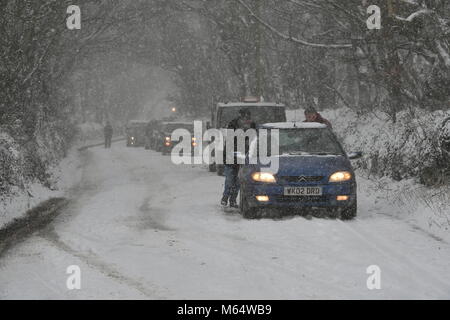 Die Menschen drücken Sie ein Auto, das auf der A 30 in der Nähe von Land's End in Cornwall gestrandet nach schweren Schnee, die Fahrbedingungen erschwert. Stockfoto