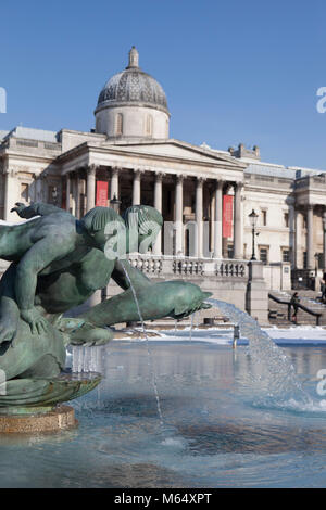 Schnee auf dem Trafalgar Square und der National Gallery und Eiszapfen auf dem Brunnen. Stockfoto