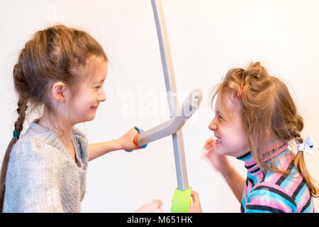 Zwei Mädchen mit Spielzeug Schwerter Ritter spielen. Deyochki argumentieren und wütend. Konflikt. Stockfoto