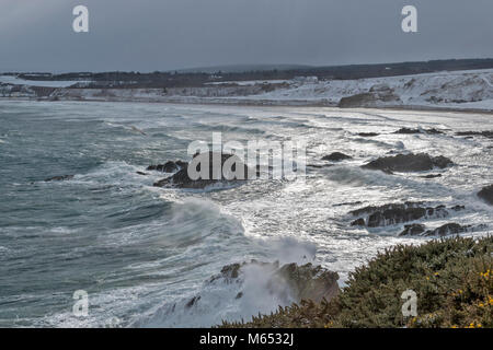 Küste von Moray in Schottland CULLEN BAY IM FEBRUAR WINTER bei starkem Wind und Schnee AUF DEN STRAND UND DEN GOLFPLATZ Stockfoto