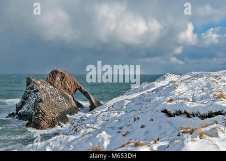 Küste von Moray in Schottland PORTKNOCKIE BOGEN GEIGE ROCK IM FEBRUAR WINTER MIT STARKEM WIND UND SCHNEE Stockfoto