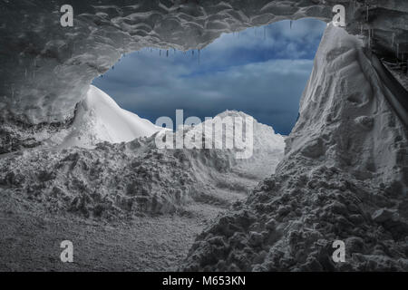 Touristen, die sich in der Crystal Cave, Breidamerkurjokull Gletscher, Island. Emerald Blue Ice und Asche ist Teil der Breidamerkurjokull. Stockfoto