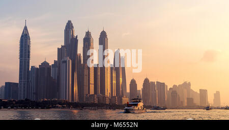 27. Dezember 2017 - Dubai, UAE. Einen malerischen Sonnenuntergang Farben auf den Wolkenkratzern widerspiegelt. Leute segeln vor der Marina. Stockfoto