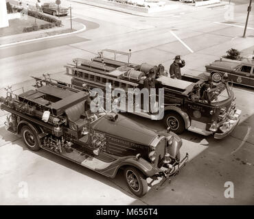 1950er Jahre 1960er Jahre Blick von oben auf die beiden LÖSCHFAHRZEUGE GEPARKT AUF DEM BAHNHOF FEUERWEHRLEUTE AUF LKW Tragen von Schutzausrüstungen-f440 HAR 001 HARS geparkten LKW FEUERWEHRMANN DISASTER BERUF HOHEN WINKEL GEFÄHRLICH SCHUTZ MUT NIEMAND GELEGENHEIT RISKANT FEUERWEHRLEUTE erhöhte Mobilität der Menschen BERUFE MÄNNER B&W SCHWARZ UND WEISS FEUERWEHR BERUFE ALTMODISCHE PERSONEN REAGIEREN. Stockfoto