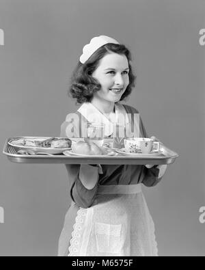 1940 Kellnerin ZIMMERMÄDCHEN DURCHFÜHRUNG FACH MIT FOOD SERVICE - h 889 HAR 001 HARS NOSTALGIE AUGENKONTAKT GLÜCK KUNDENSERVICE KNECHT LÄCHELT fröhlich-freundlich ANGENEHME WAITPERSON JUNGEN ERWACHSENEN FRAU B&W SCHWARZ UND WEISS KAUKASISCHEN ETHNIE AUF KAMERA BERUFE ALTMODISCHE PERSONEN MITARBEITER WARTEN Stockfoto