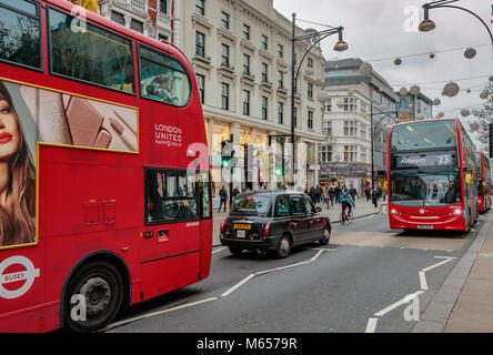 Ein schwarzes Taxi und zwei Londoner Busse auf Oxford St, London Stockfoto