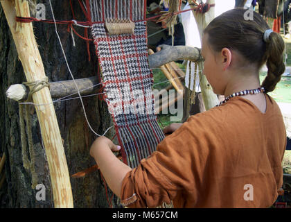 Smolensk, Russland - August 09, 2014: Frau macht Tuch auf einem alten Webstuhl. Festival der historischen Rekonstruktion' Nest-2014' Stockfoto