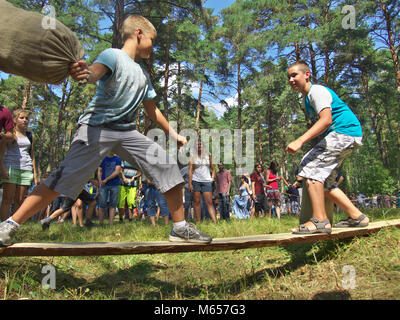 Gnezdovo, Russland - August 09, 2014: Zwei Jungen sind in der russischen nationalen Zeitvertreib beteiligt - der Kampf Beutel auf der Platine an der historischen Festival in Gn Stockfoto