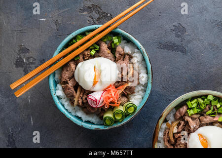 Gyudon - japanische Reis und Rindfleisch Schüssel auf dunklem Hintergrund Stockfoto