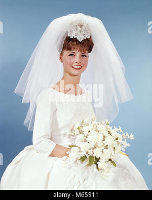 1960 Portrait lächelnde Frau Braut IN EINFACHEN WEISSEN BRAUTKLEID HOLDING WHITE FLOWER BOUQUET AUF KAMERA-kb5240 HAR 001 HARS KOPIE RAUM MIT HALBER LÄNGE DAMEN EHE DRINNEN SCHLEIER ZEREMONIE NOSTALGIE BRIDAL AUGENKONTAKT 20-25 Jahre 25-30 JAHRE BRUNETTE ZIELE PERSONEN GESCHICHTE TRÄUME GLÜCK FRÖHLICHE BRÄUTE AUFREGUNG Lächeln freudigen Ritus der Passage MI HEIRATEN EHE EHE JUNGE ERWACHSENE FRAU KAUKASISCHEN ETHNIE AUF KAMERA ALTMODISCHE PERSONEN Stockfoto