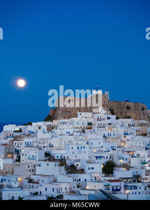 Chora von Astypalea in der blauen Stunde und der volle Mond hinter der Festung Stockfoto