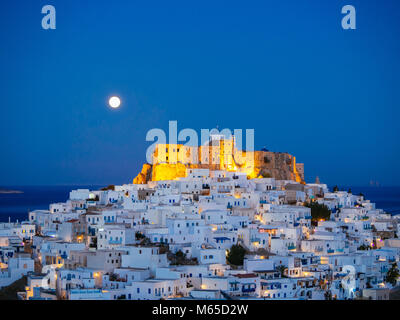 Chora von Astypalea in Blaue Stunde mit dem Vollmond hinter den erleuchteten Festung Stockfoto