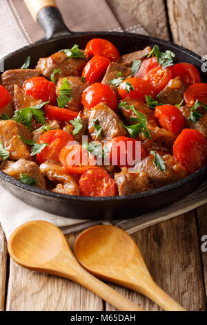 Hausgemachte Roastbeef mit Sauce und Cherry Tomaten und grünen Close-up in einer Pfanne. Vertikale Stockfoto