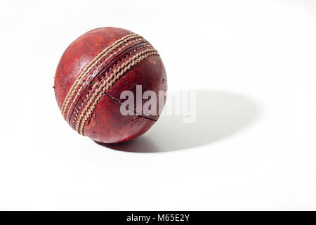 Dunkelrot ältere Cricket Ball auf weißem Hintergrund Stockfoto