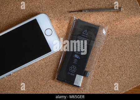 Home DIY-Austausch eines iPhone 5s Akku, Telefon mit neuen und alten Batterie und Interna von Telefon geöffnet. Stockfoto