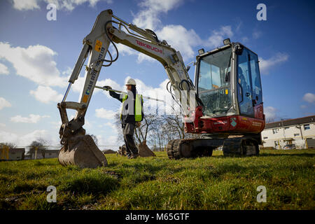 Arbeiter auf der Baustelle neben einem Mini Bagger Stockfoto