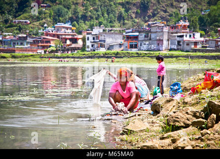 POKHARA, Nepal - Mai 25: Familie waschen Tuch in Fewa See am 25. Mai 2013, Pokhara, Nepal. Einer der schönsten Seen von Pokhara Tal ist die Kn Stockfoto