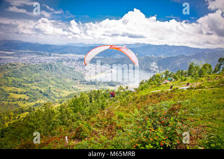 POKHARA, Nepal - Mai 25, 2013: Gleitschirm Gleitschirme von SARANGKOT am 25. Mai in Pokhara, Nepal 2013. Hauptsächlich für Paragliding in Nepal Stockfoto